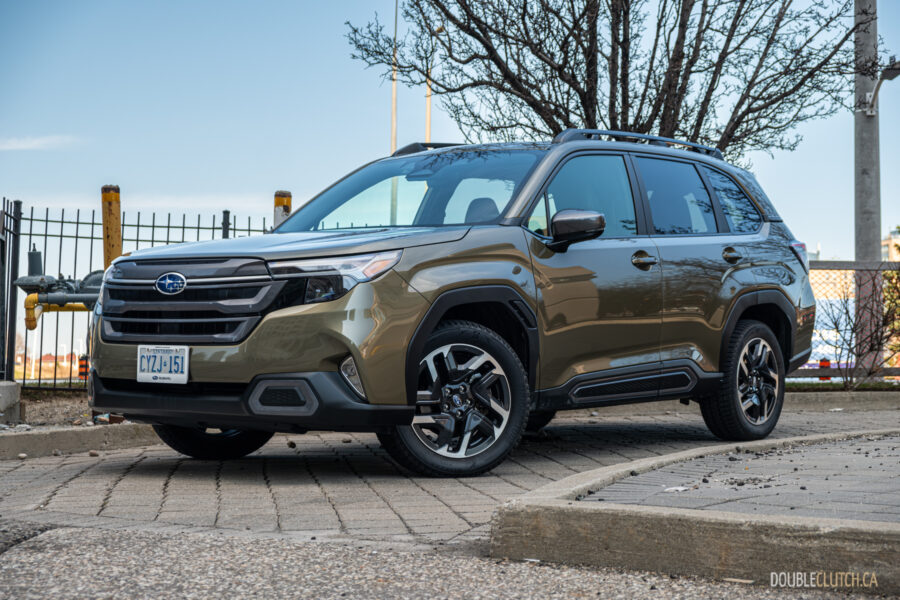 Front quarter view of a green 2025 Subaru Forester in a parking lot and tree in the background