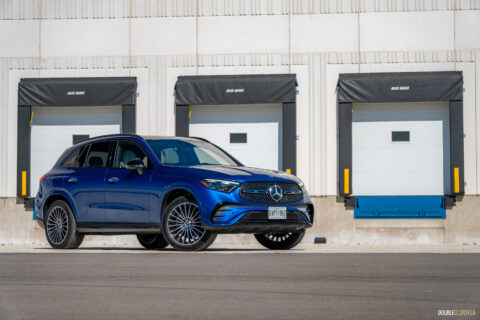 Front quarter view of a blue 2025 Mercedes-Benz GLC 350e with a building in the background
