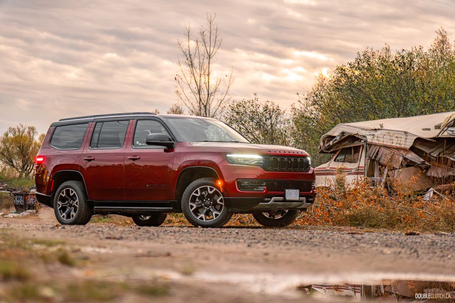 2025 Jeep Wagoneer Overland Edition in Velvet Red positioned menacingly next to a destroyed Winnebago