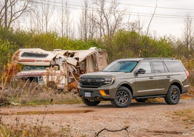 2025 Ford Expedition Tremor in Wild Green positioned menacingly next to a destroyed Winnebago